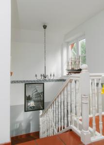 a white staircase in a home with a chandelier at Gästehaus Vigliarolo in Elmshorn