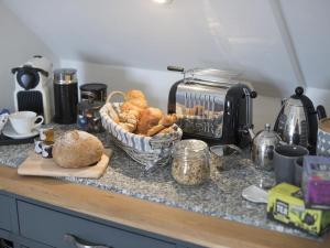 a kitchen counter with a basket of bread and a toaster at chyreen@marazion in Marazion