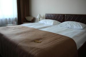a hotel room with a bed with a brown blanket at Hotel Yubileiny in Minsk
