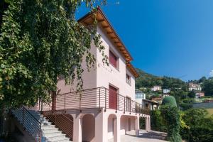 a building with stairs and a hill in the background at Villa Vittoria - The House Of Travelers in Cernobbio