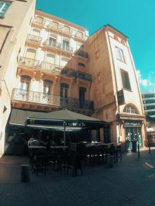 a building with tables and chairs in front of a building at Studio des Carmes in Toulouse