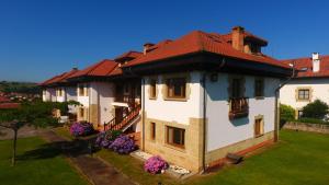 una gran casa blanca con techo rojo en Apartamentos Ciudad de Petra, en Santillana del Mar