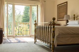 a bedroom with a bed and a view of a balcony at Sedlescombe Golf Hotel in Sedlescombe