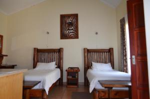 a room with two beds and a table at Zebra Guesthouse in Lephalale