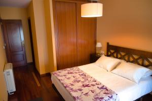 1 dormitorio con 1 cama y 1 lámpara en Apartamento en Beiramar, en O Grove