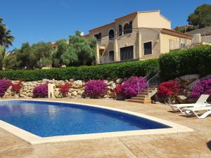 una piscina frente a una casa en Casa Josemar - Casa con piscina junto a la playa en Cala Romántica, en Cala Romántica