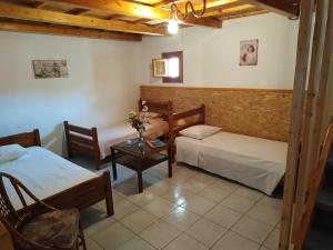 a room with two beds and a table and chairs at Theanos House in Pigi