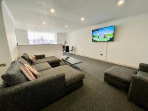 a living room with two couches and a flat screen tv at Fabrik Apartments - Harrowside by Blackpool Service Apartements in Blackpool