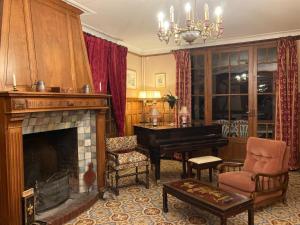a living room with a fireplace and a piano at Domaine des Thomins in Cisai-Saint-Aubin