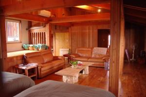 een woonkamer met lederen meubels en een bank bij Miyajima Breeze in Hatsukaichi