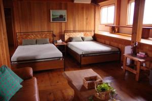 a living room with two beds and a couch at Miyajima Breeze in Hatsukaichi