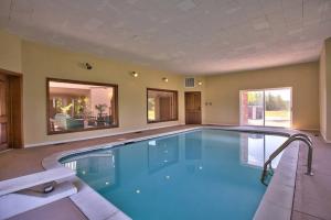 a large swimming pool with blue water in a room at Grand Villa Estate in Burlington