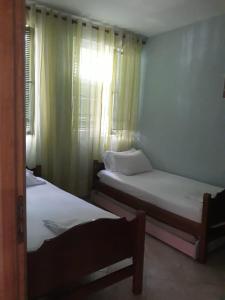 two beds in a room with a window at A beautiful Beach house Marea Resort in Golem +19 photos