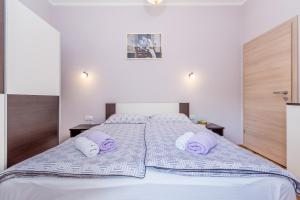 sypialnia z dużym łóżkiem z fioletowymi poduszkami w obiekcie Apartments Krc w mieście Pinezići