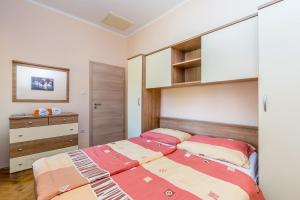 a bedroom with two beds and a dresser at Apartments Krc in Pinezici