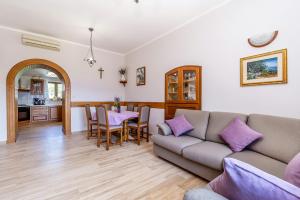 a living room with a couch and a table with purple pillows at Apartments Krc in Pinezici