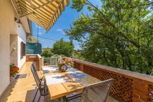 drewniany stół i krzesła na balkonie w obiekcie Apartments Krc w mieście Pinezići