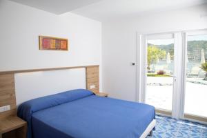 a bedroom with a blue bed and a window at FURANO BAHARI in Agropoli
