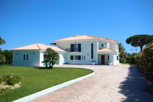 a large white house with a driveway at Villa Fonte Santa in Quarteira