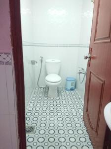 a bathroom with a toilet and a black and white tile floor at Hostel Garnet in Can Tho