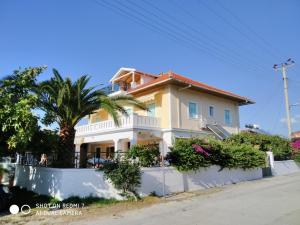 a yellow house with a fence in front of it at Splantza Apartments in Ammoudia