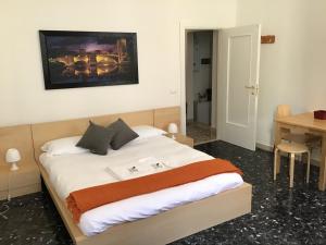 um quarto com uma cama com lençóis brancos e um cobertor laranja em A due passi da Giulietta-Casa Capuleti em Verona