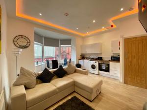a living room with a couch and a kitchen at Princess Theatre Beach View Apartments in Blackpool