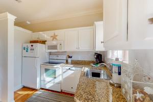 a kitchen with white appliances and white cabinets at Sunday House in Pensacola