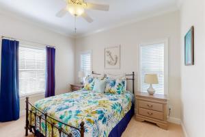 a bedroom with a bed and two windows at Sunday House in Pensacola