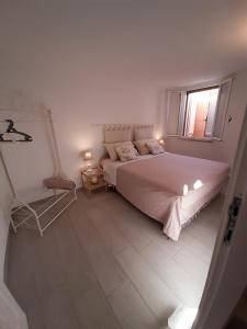 Habitación blanca con cama y ventana en Sun Sea and relax villetta a due passi dal mare, en Solanas