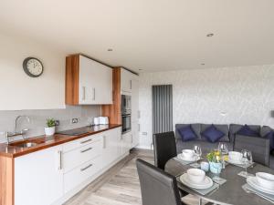 une cuisine et une salle à manger avec une table et un canapé dans l'établissement Meadow Lodge, à Corwen