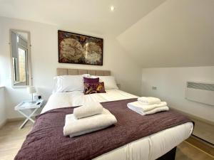 a bedroom with a large bed with towels on it at Princess Theatre Beach View Apartments in Blackpool