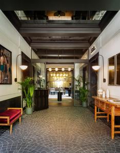 a lobby with tables and potted plants in a building at Radisson Blu Hotel, Madrid Prado in Madrid