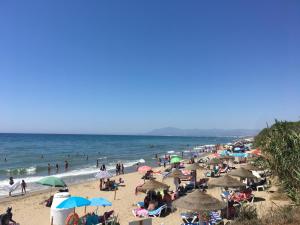 a group of people on a beach with umbrellas at Marbella Deluxe Rooms in Royal Cabopino Townhouse in Marbella
