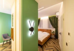 een slaapkamer met een bed en een groene muur bij Art’partment in Braşov
