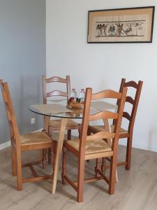 a dining room table with four chairs and a table and a picture at Reflets de la Mer... in Plomodiern +52 photos