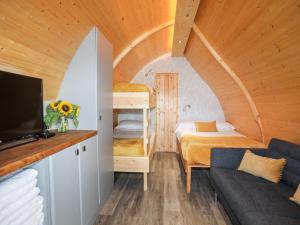 Habitación pequeña con litera y sofá en Woodland Pod, en Corwen