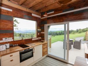 cocina con puertas correderas de cristal y patio en Woodland Pod, en Corwen