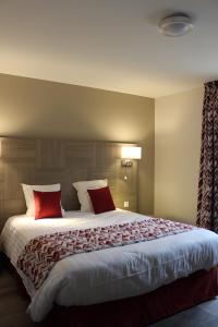 Vaux-sous-AubignyにあるHotel le Vauxoisのベッドルーム1室(大型ベッド1台、赤い枕付)