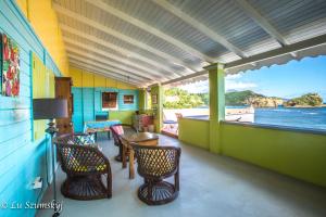 a room with chairs and a table on a boat at Veranda View Guesthouse in Calibishie