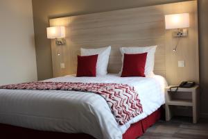 Vaux-sous-AubignyにあるHotel le Vauxoisの大きなベッド(赤い枕付)が備わる客室です。