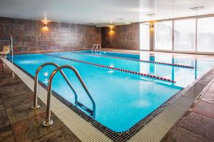 a large indoor swimming pool with blue water at AZZ Valencia Táctica Hotel in Paterna