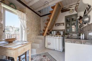 a kitchen with a counter and a table in a room at Nido di Modica con vista in Modica