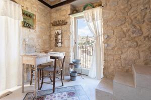 a stone room with a table and a window at Nido di Modica con vista in Modica +6 photos