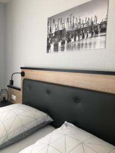 a bedroom with a bed with a picture on the wall at Appartement Rehn Büsum in Büsum