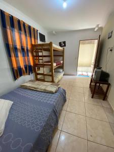 a bedroom with a bed and a tv in it at Pousada J.C. Cazeri in Santos