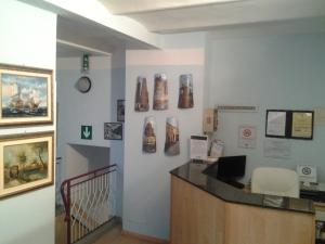 una hall con scrivania e alcune scarpe sul muro di Hotel Perla a Bologna