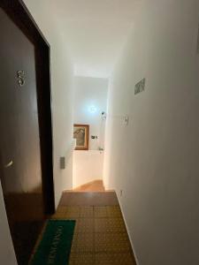 a room with a hallway with a door and a tile floor at Pousada J.C. Cazeri in Santos