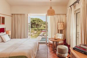 a hotel room with a bed and a balcony at Hotel Lou Pinet in Saint-Tropez