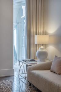 a living room with a couch, chair and a lamp at Santiago de Alfama - Boutique Hotel in Lisbon